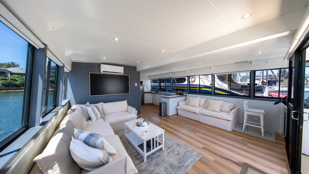 Deckhouse interior - air-conditioned saloon with lounges, flatscreen TV and galley kitchen